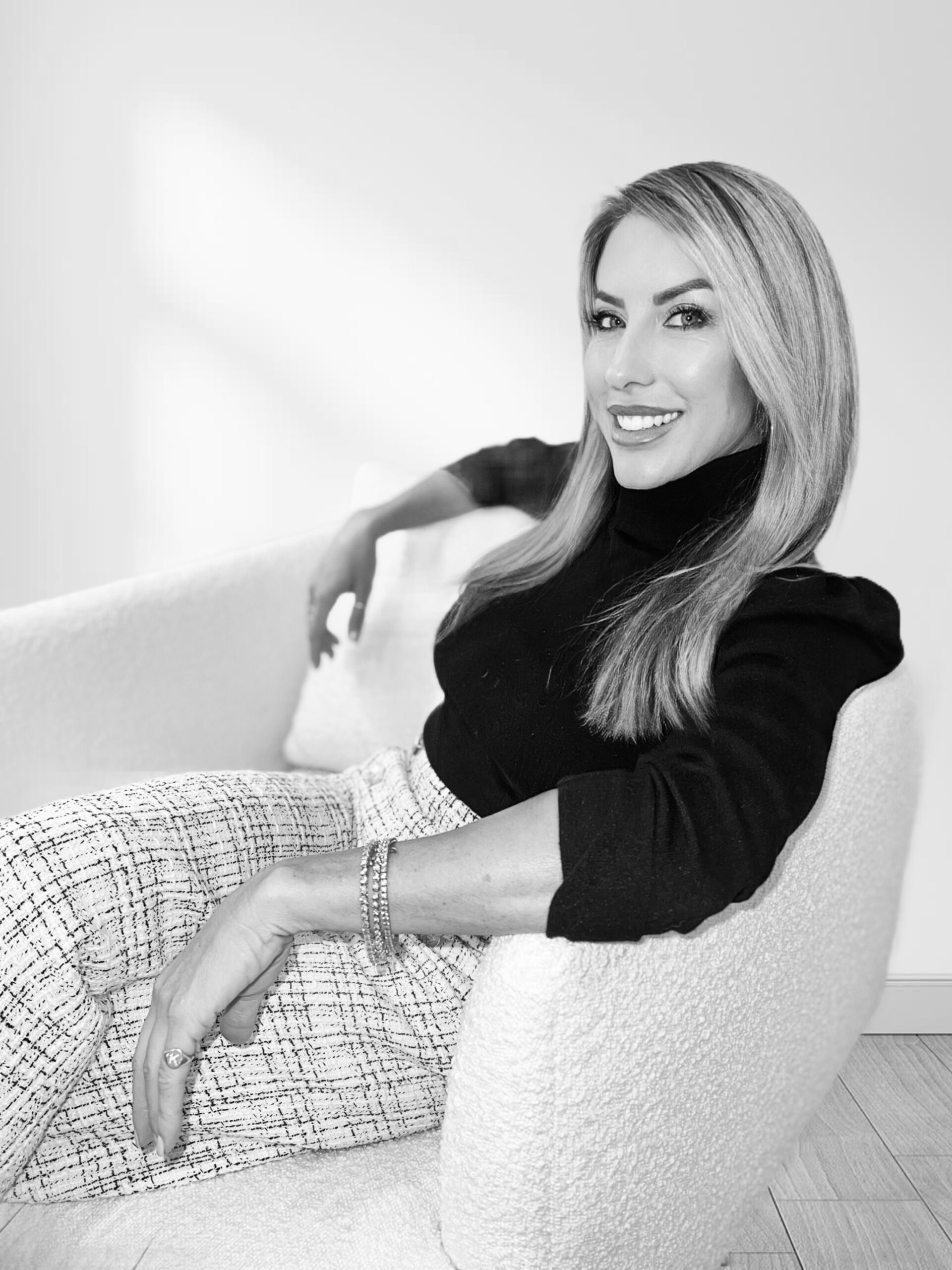 Katy Clark in black and white sitting on a chair dating coach for Orange County